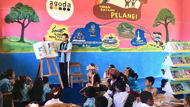 Sukarelawan dari kegiatan wisata travel sparks membacakan buku untuk anak-anak