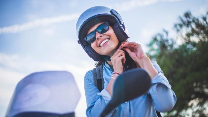 Ilustrasi wanita naik motor. 
